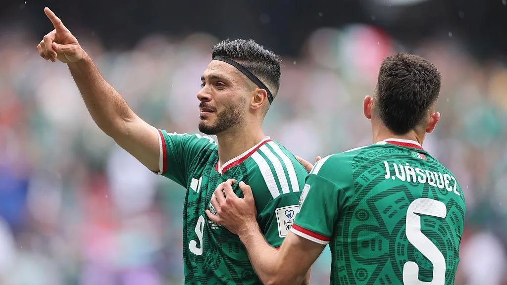 Raul Jimenez, in largely green kit, points to someone out of shot as he celebrates scoring for Mexico